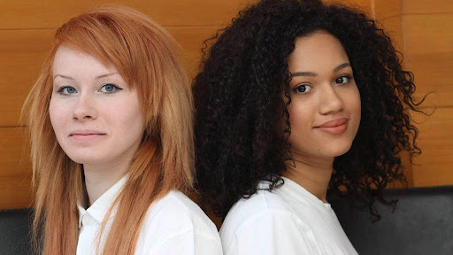 two young women standing back-to-back representing diversity and inclusion in the workplace